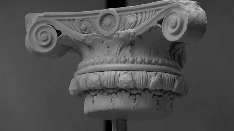 Composite capital on a stand in a grey studio